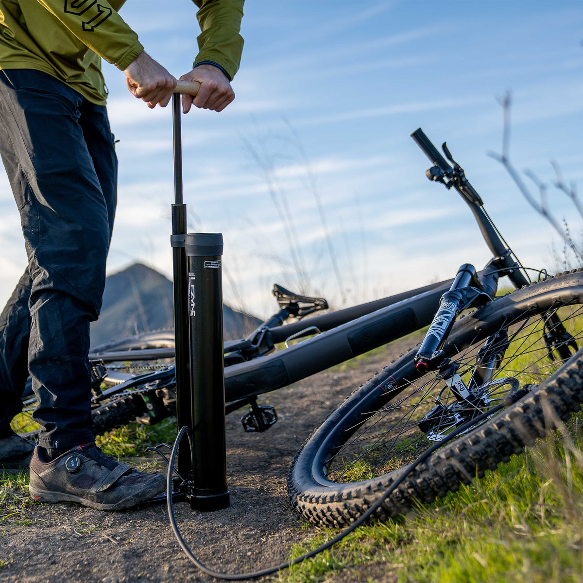 Lezyne fotpump står på marken bredvid cykel, redo att pumpa däck
