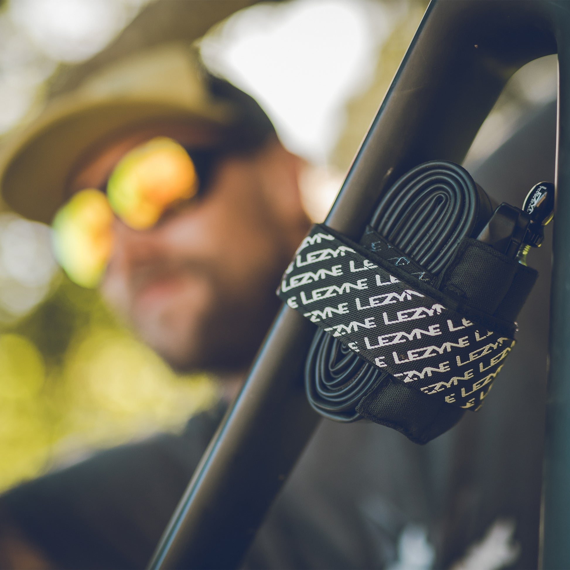 Tillbehörshållare med svart och vit textmönstrad ficka på cykelram