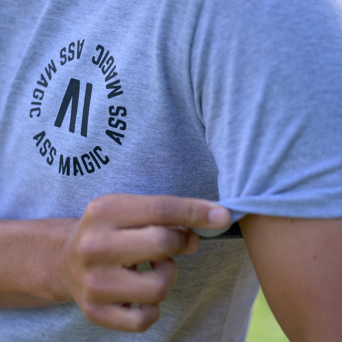 Ljusblå T-shirt med runt texttryck och kort ärm, närbild vid midjan