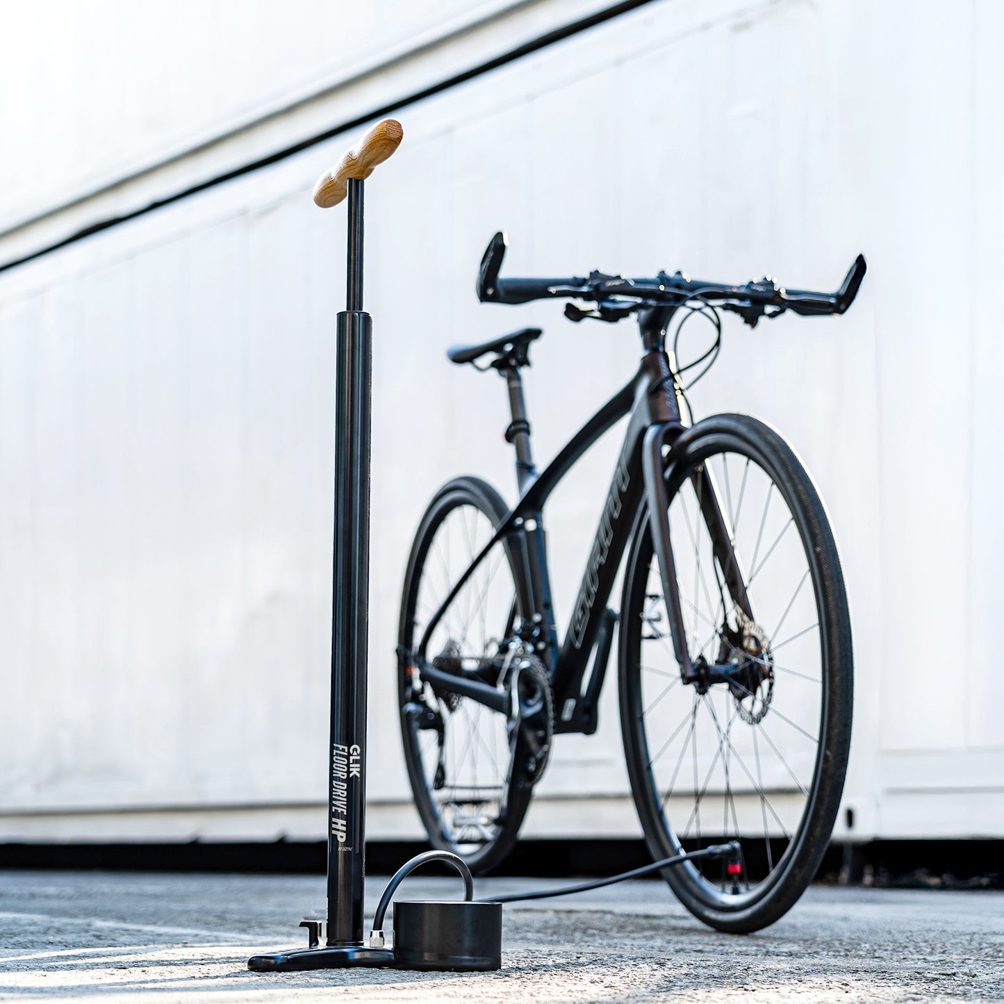 Cykelpump på golvet, svart stativ med trähandtag och fotplatta