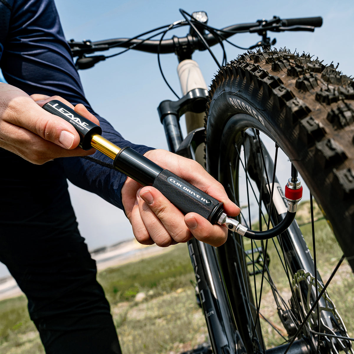 Lezyne handpump med svart texturgrepp och gul slang, kopplad till cykelventil.