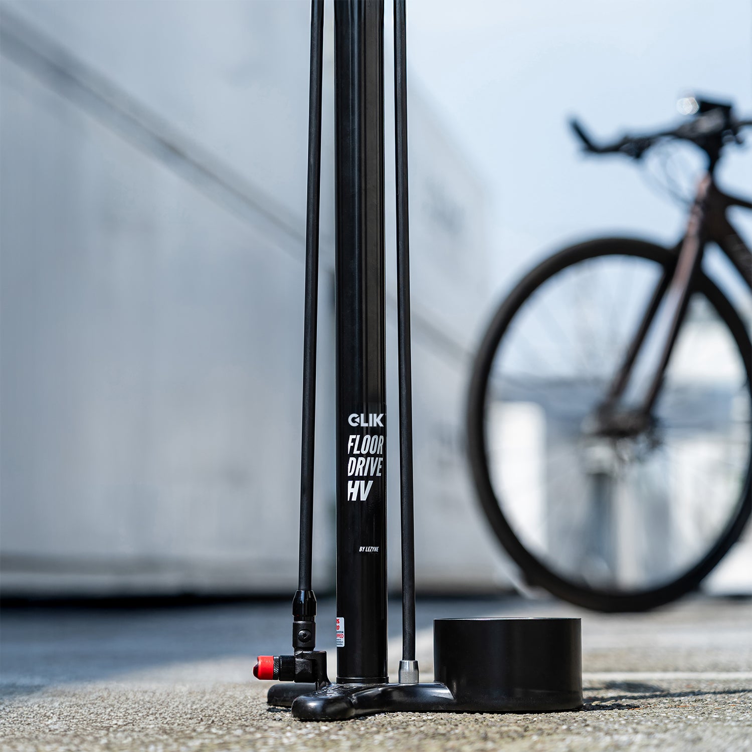 Cykelgolvpump med dubbelstång, svart fot och manometer vid sockeln