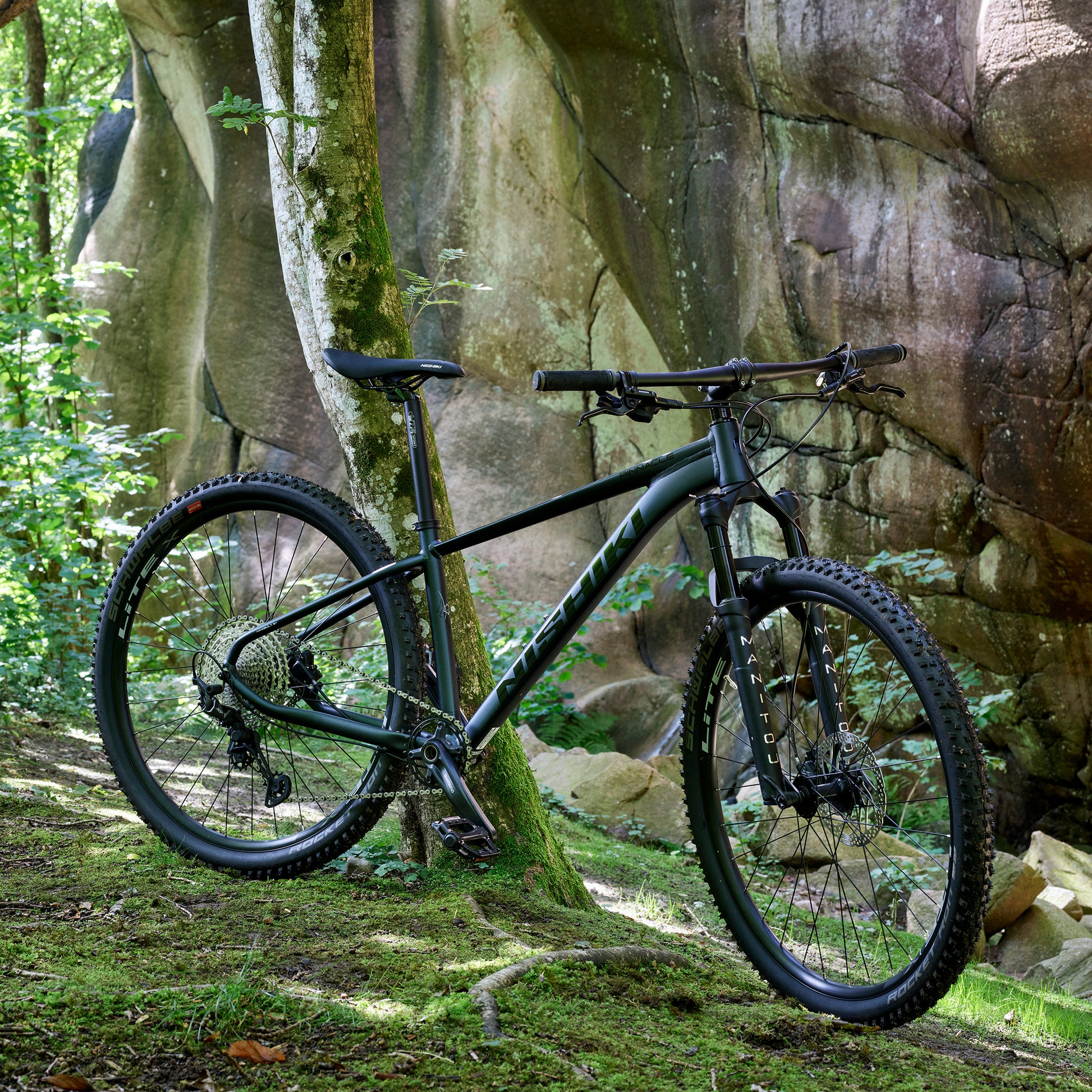 Mörkblå mountainbike sedd från sidan med breda däck och skivbroms