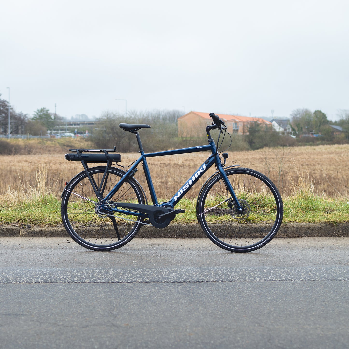 Elcykel Nishiki Master E i blått med pakethållare, framlykta och kedjeskydd